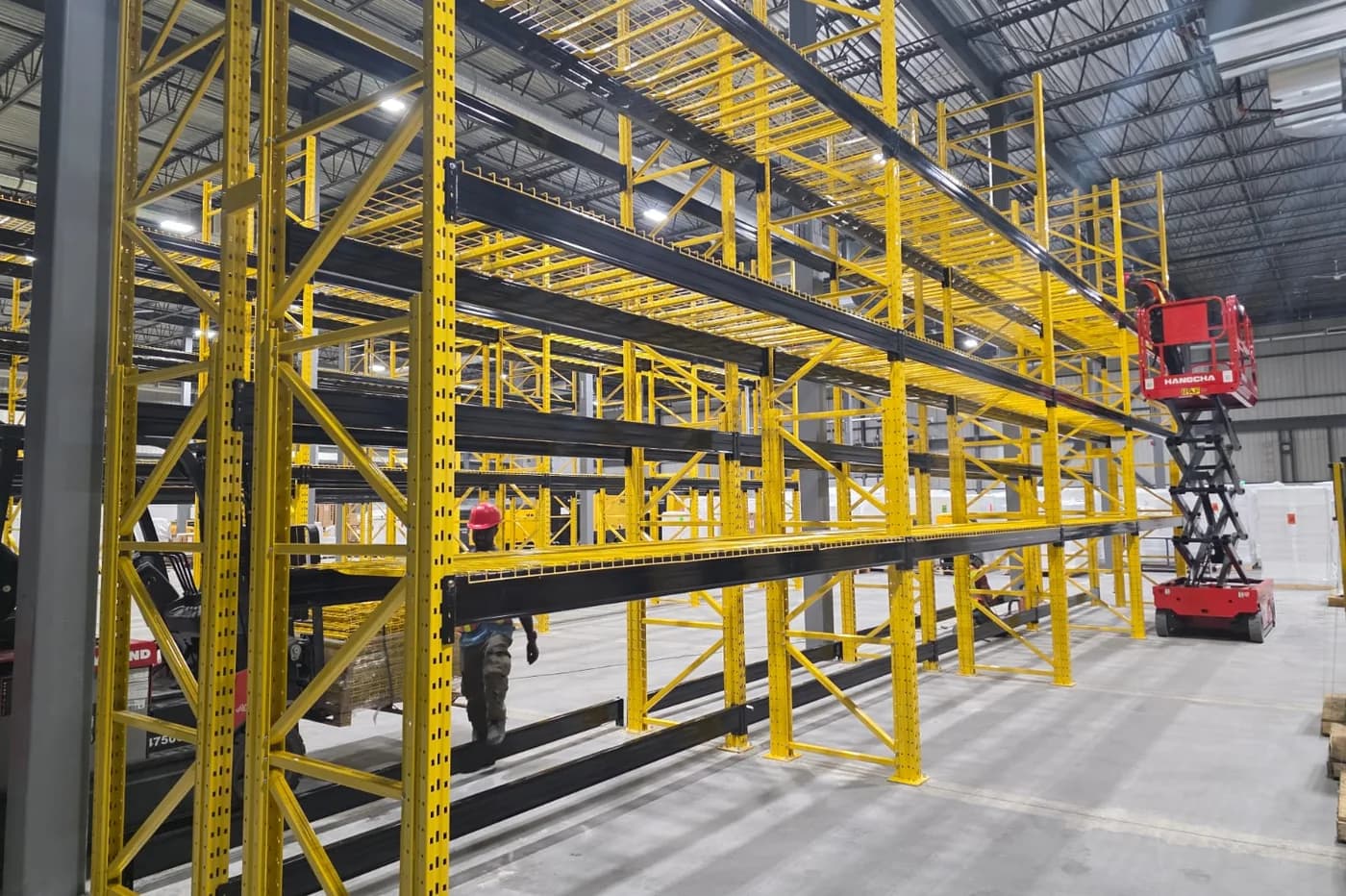 Pallet racking installation by the 3E Racking Systems crew with a scissor lift